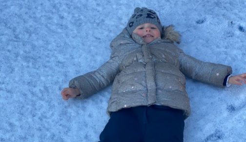 girl making a snow angel